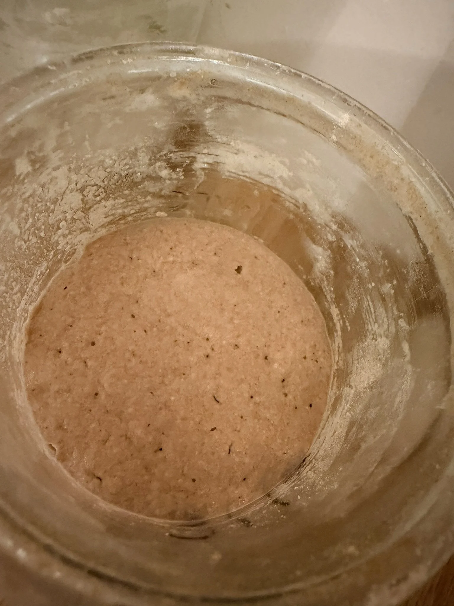 Close-up view of the inside of a dirty, stained glass jar with dust and residue.