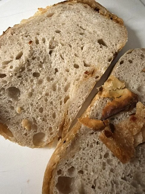 Slices of bread with a crispy crust and airy interior on a white plate.