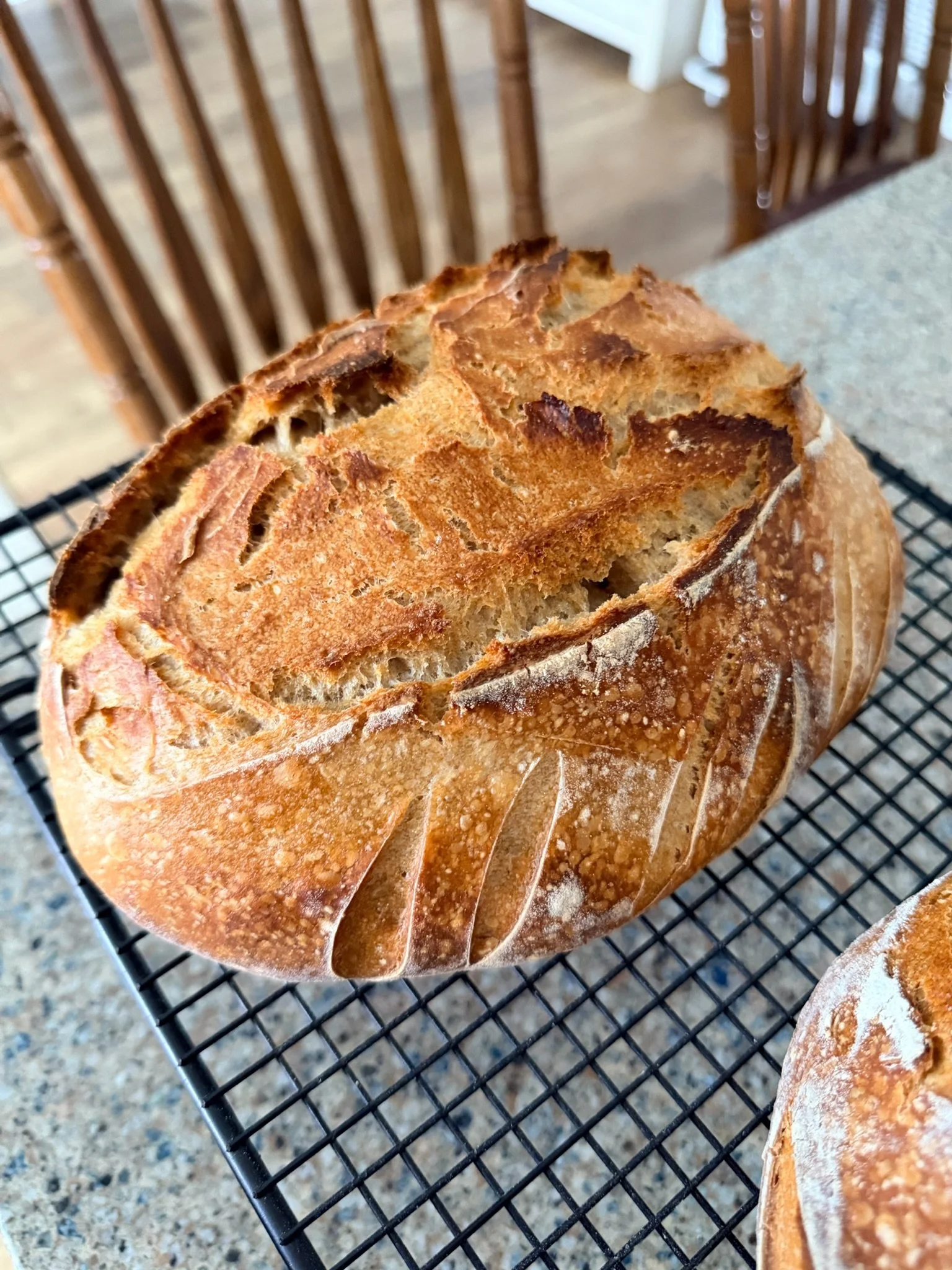 Close-up of sliced loaf of bread on a cooling rack on a kitchen counter.