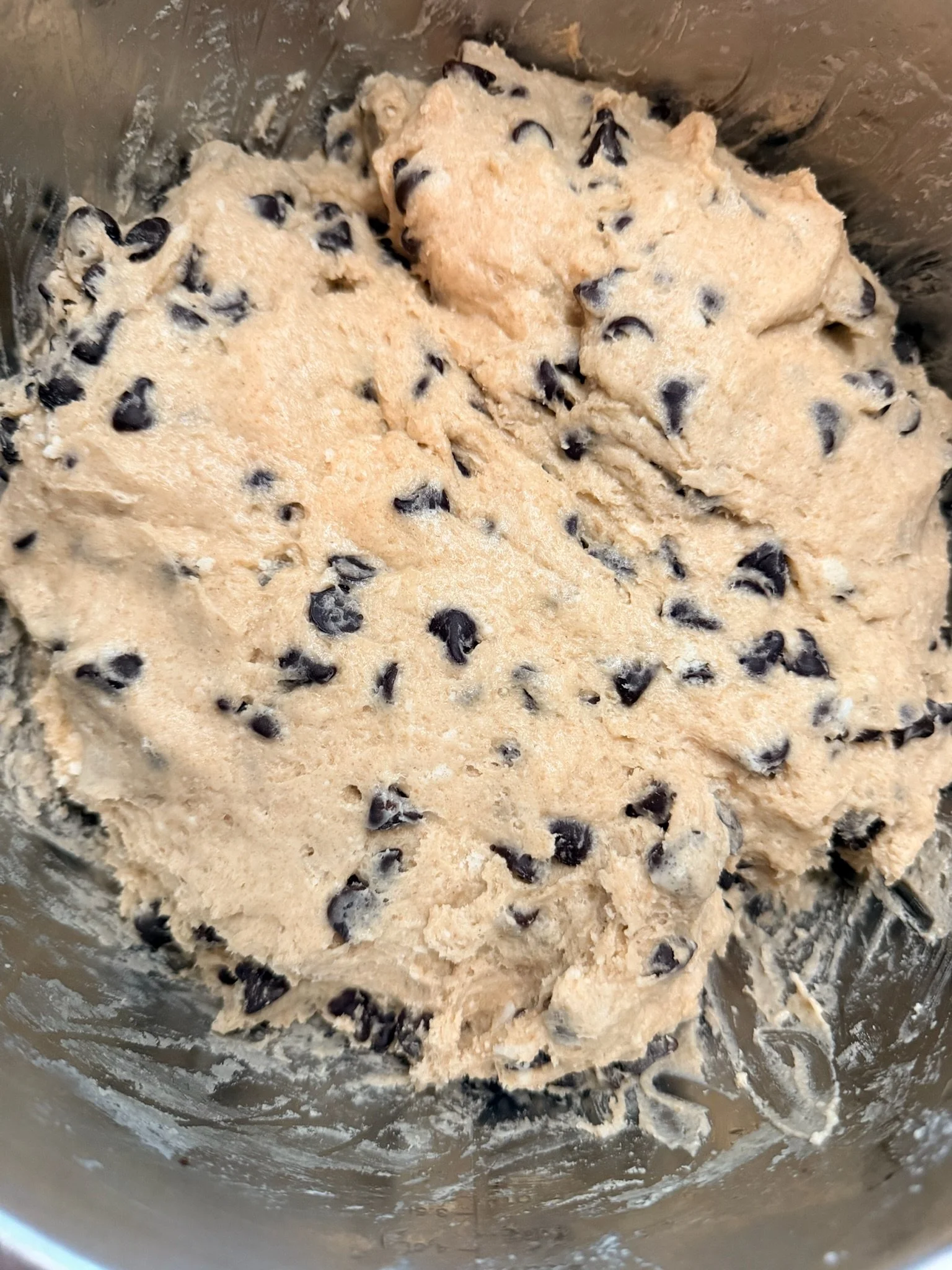 Raw chocolate chip cookie dough in a mixing bowl.