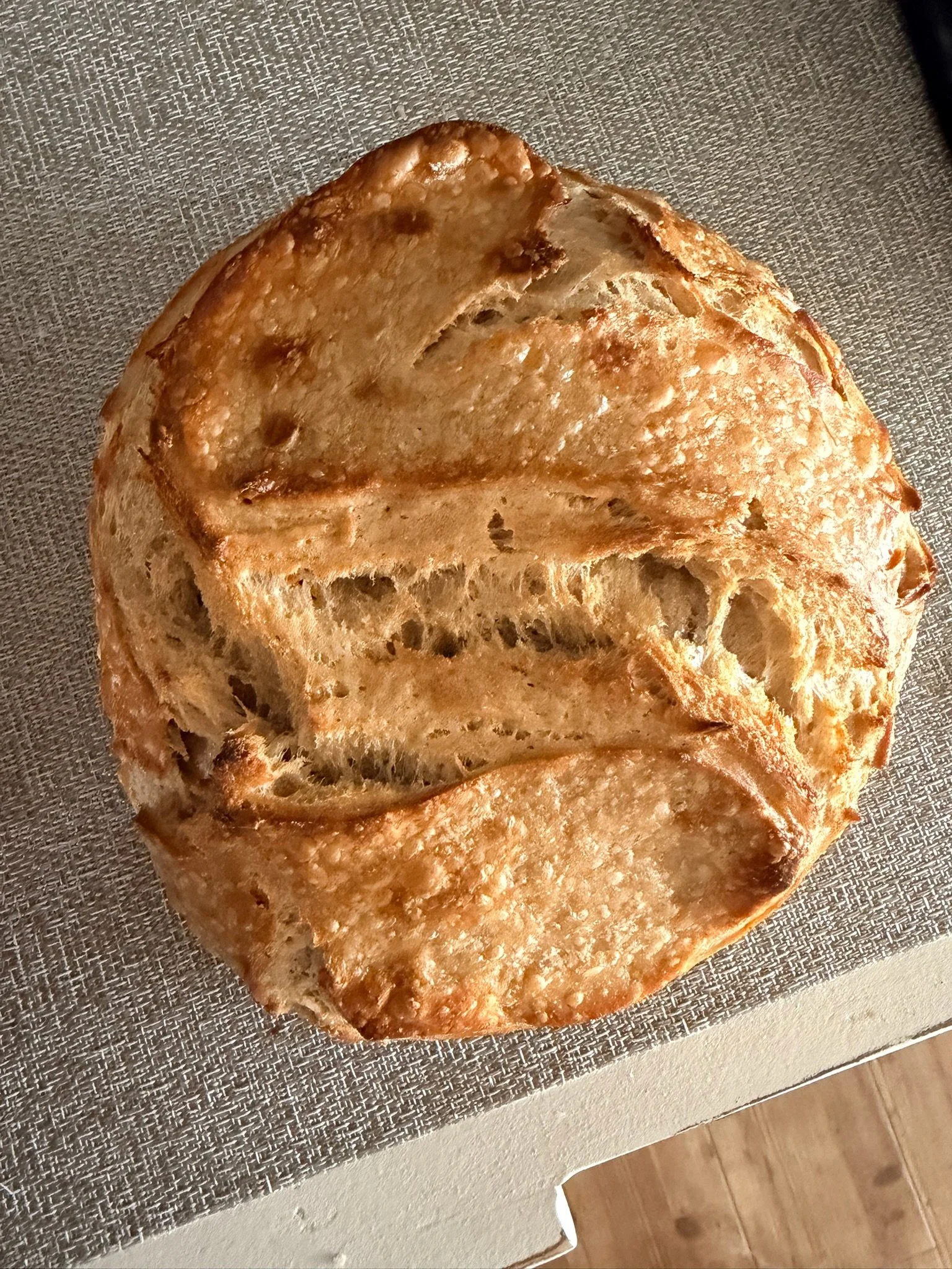 Close-up of a sliced loaf of bread on a textured surface.
