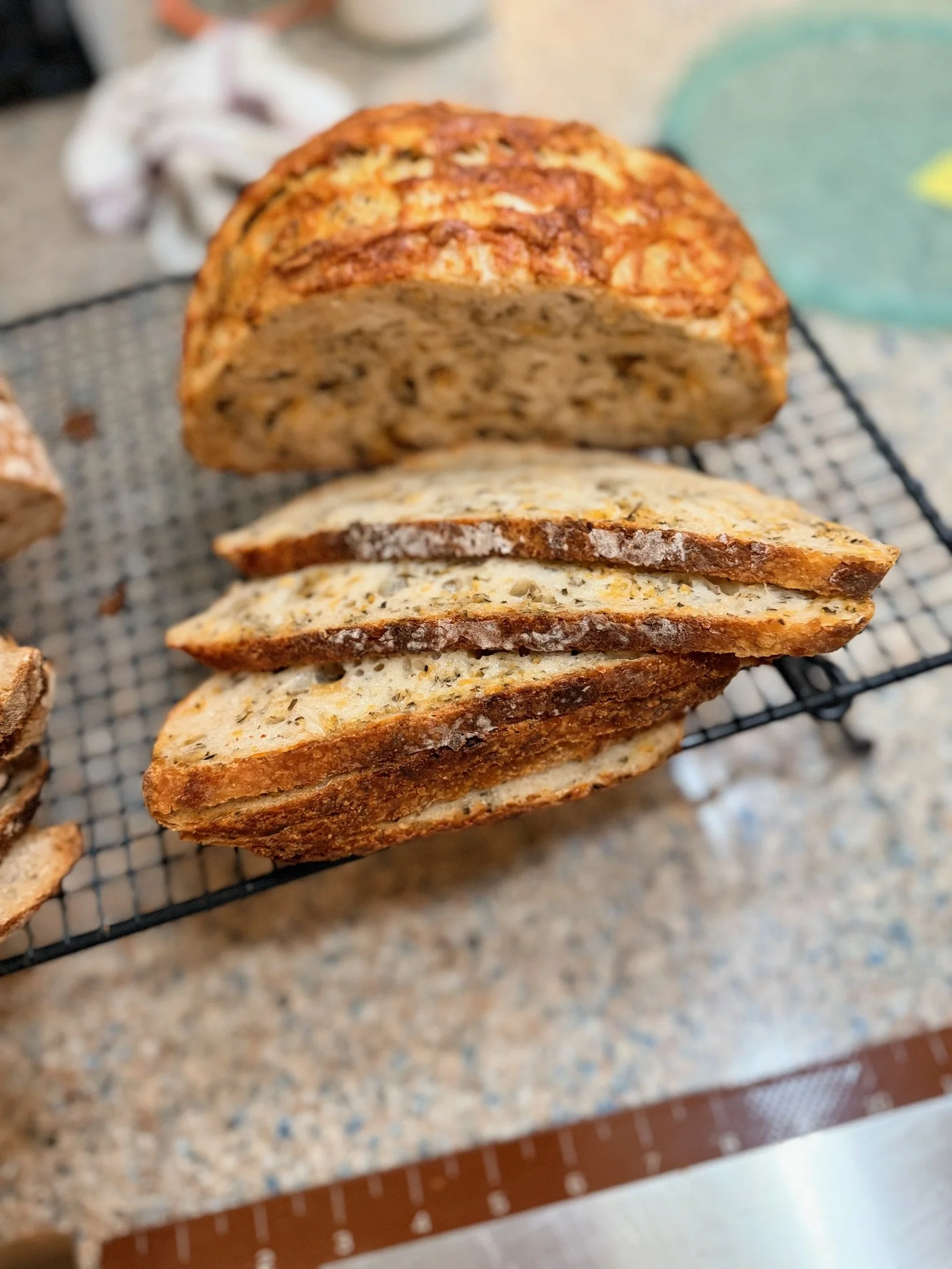 Slices of multigrain toast placed on a wire rack on a kitchen countertop.