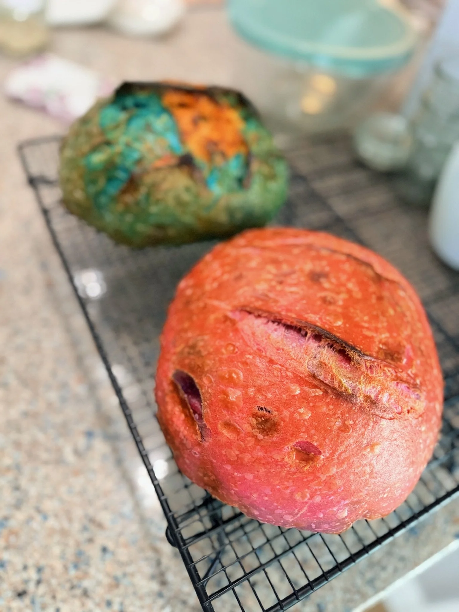 Close-up of a roasted pumpkin on a wire rack with a blurred background of kitchen items.