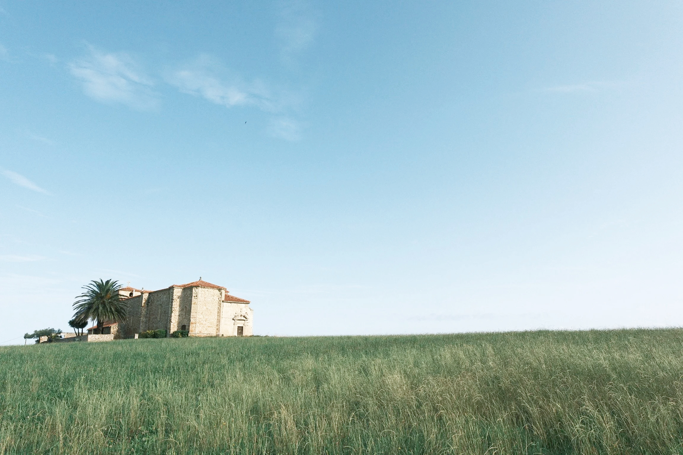 Spanish house lying on horizon with wild grass in foreground