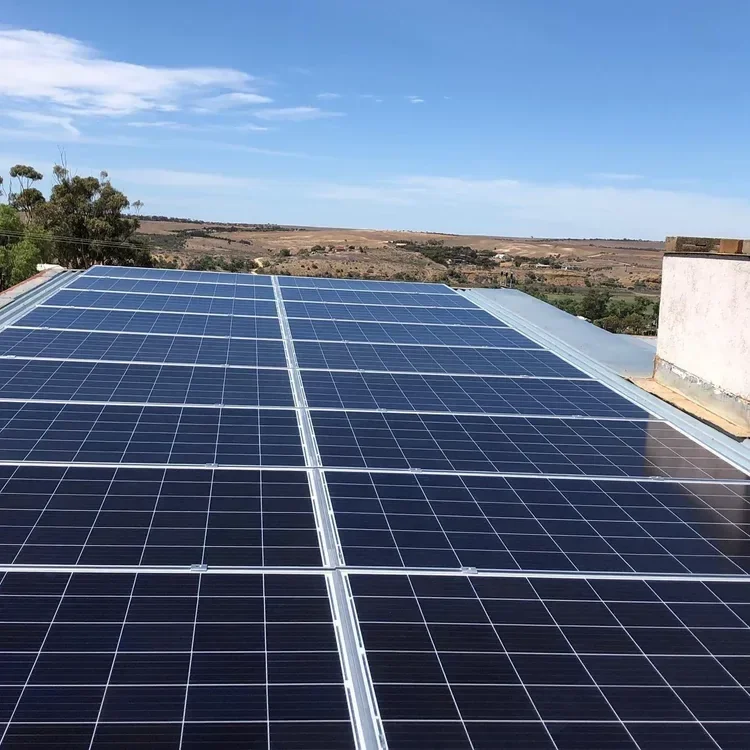 Solar panels installed on a rooftop under a clear blue sky.