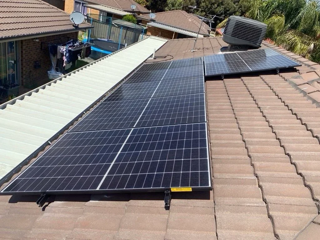 Solar panels installed on a rooftop along with an air conditioning unit.