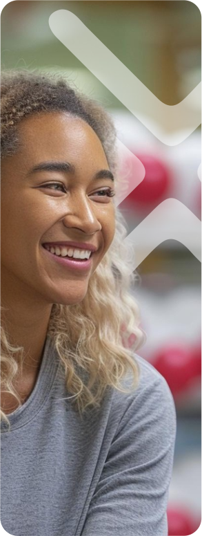 Young woman with curly hair smiling outdoors.