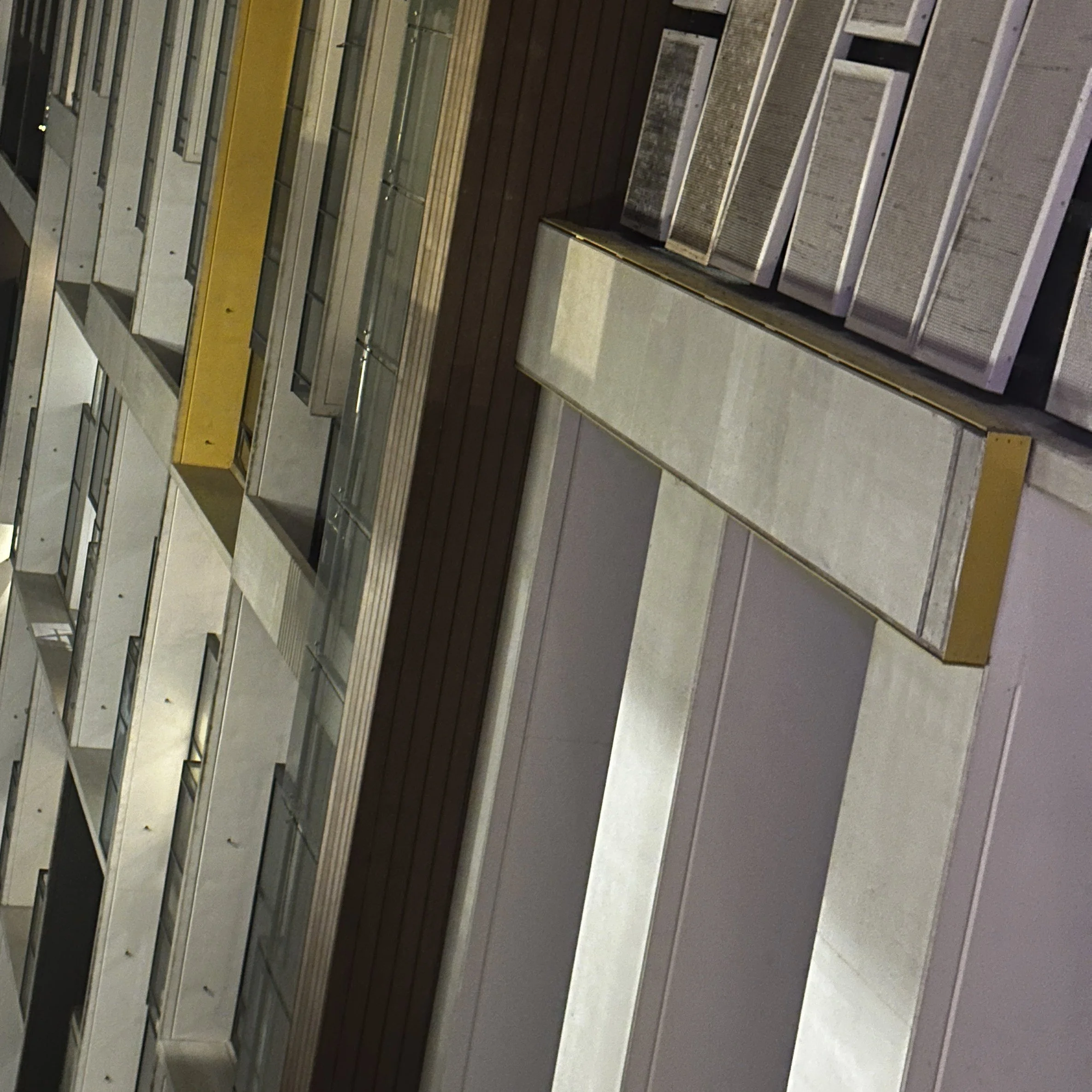 Multiple empty benches arranged in rows on a tiled floor in an indoor setting.