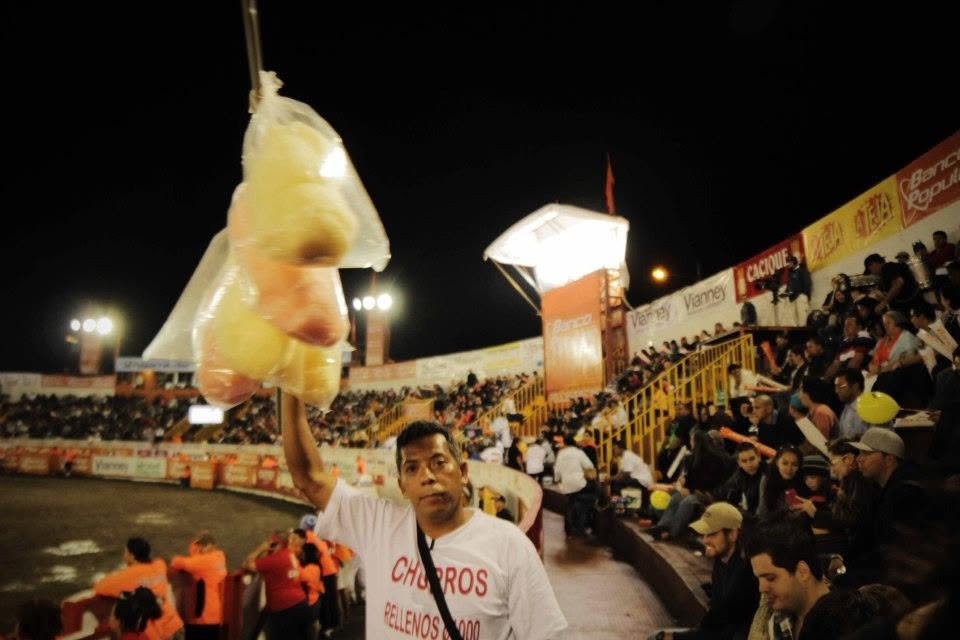Vendor carrying cotton candy during a crowded community festival at night