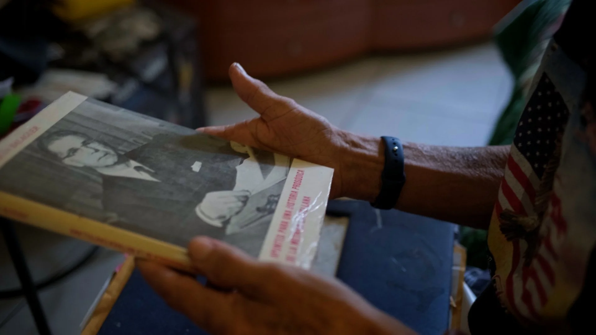Hands reviewing family archive photographs in My Grandfather Is Not In This Story, a documentary about migration and identity.
