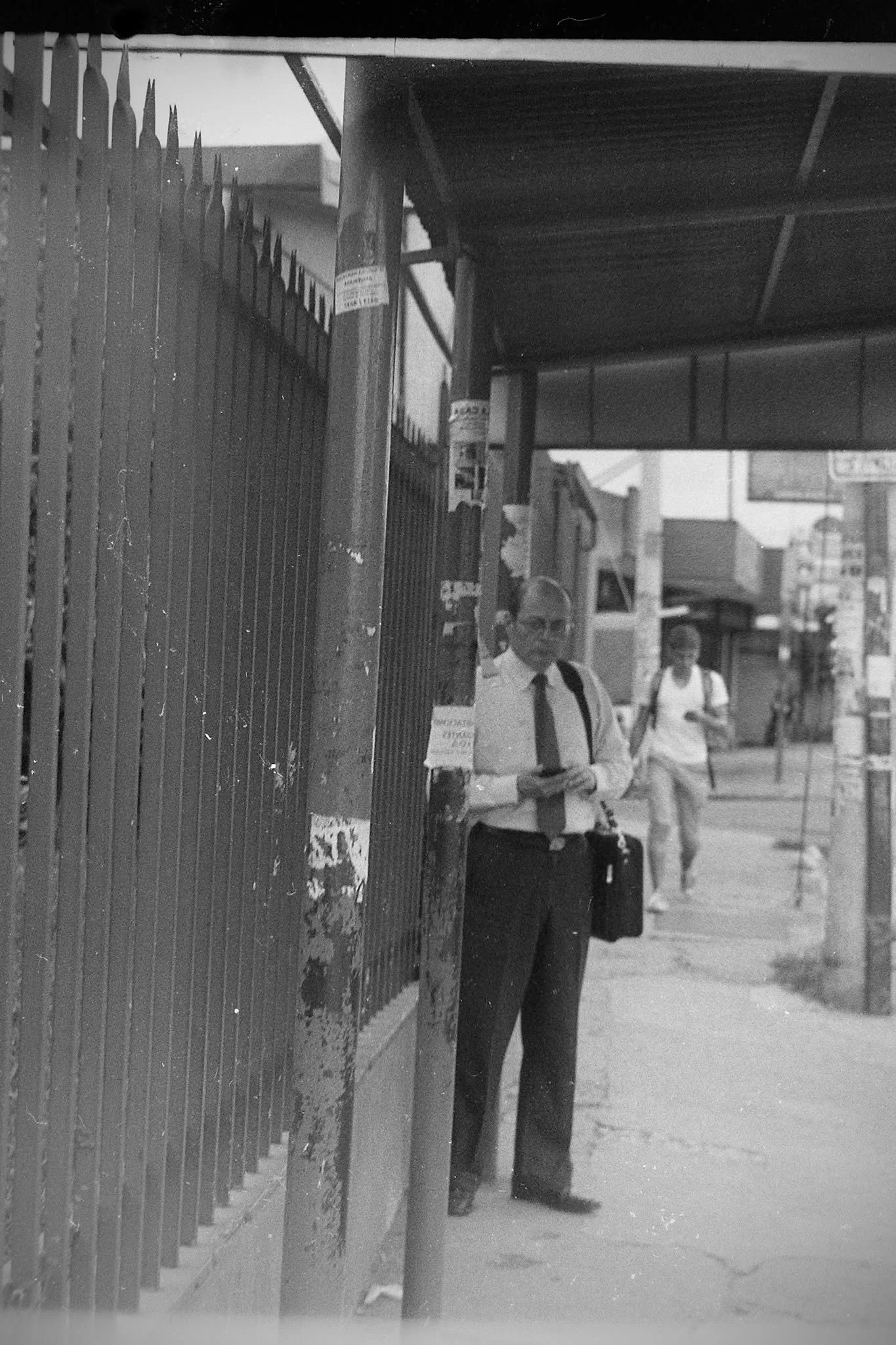Man walking through a narrow urban street carrying papers