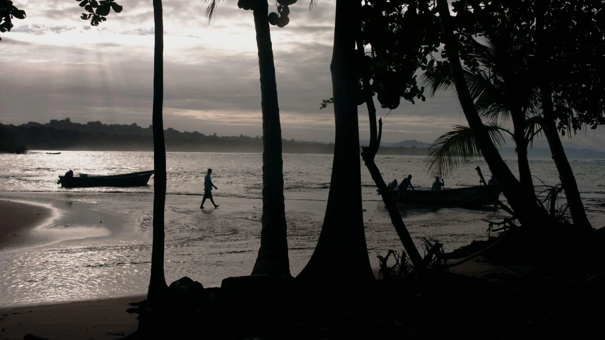 Siluetas de pescadores al atardecer frente al mar Caribe en Puerto Viejo de Talamanca, Limón, Costa Rica.