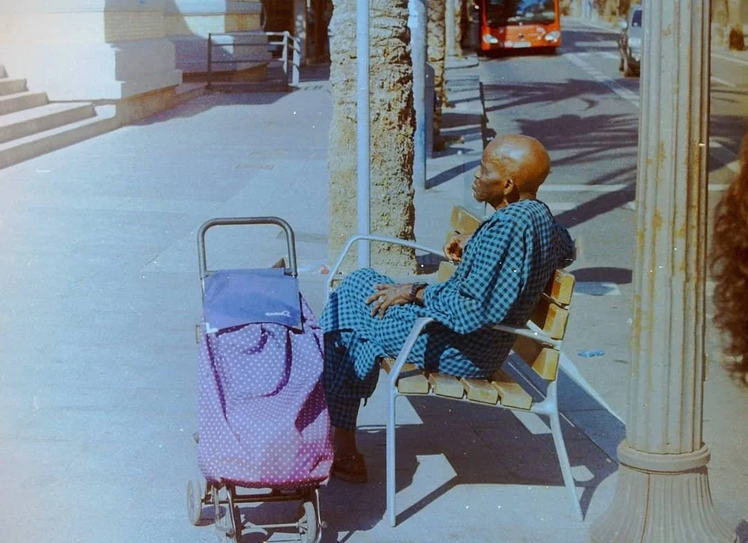 Elderly  sitting alone outside a building entrance