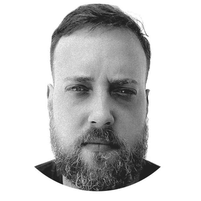 Close-up black and white portrait of a man with a beard and short hair, looking directly at the camera with a serious expression, against a plain background.