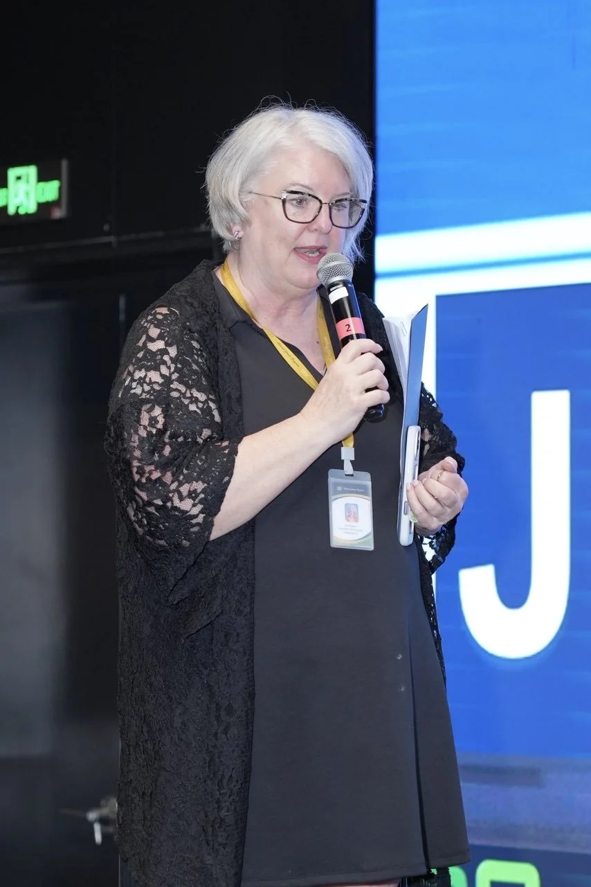 Jillian Miesen speaking into a microphone. Expert professional development and educational consulting for school districts.