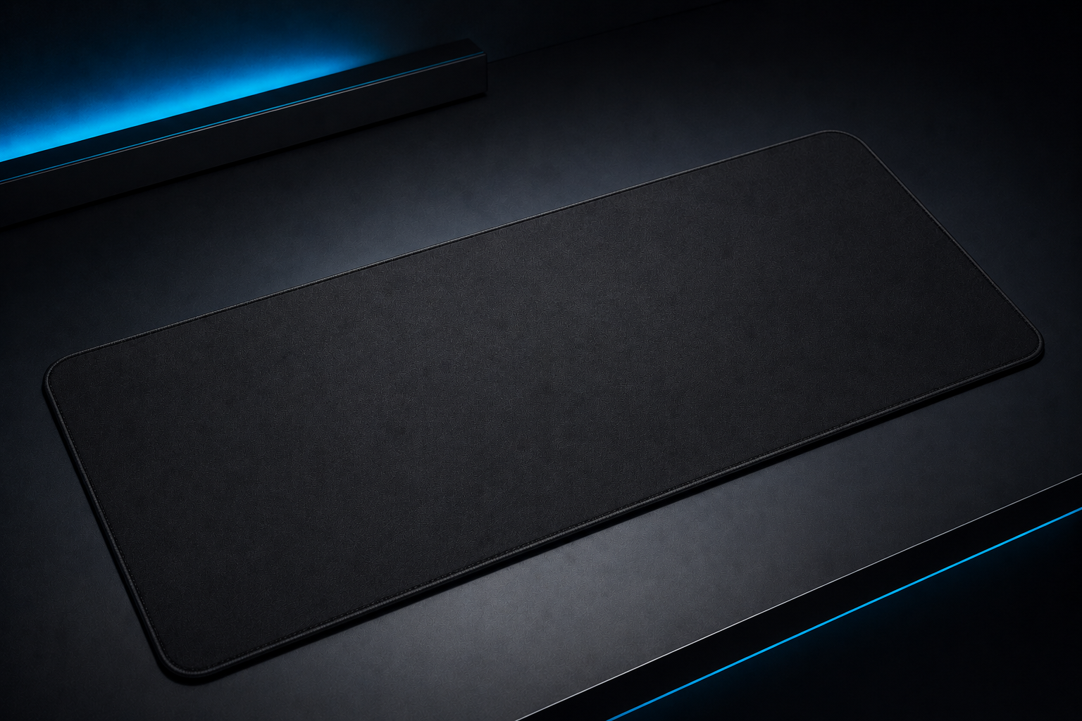 A black rectangular object, possibly a mouse pad or desk mat, placed on a dark surface with ambient lighting creating a subtle glow.