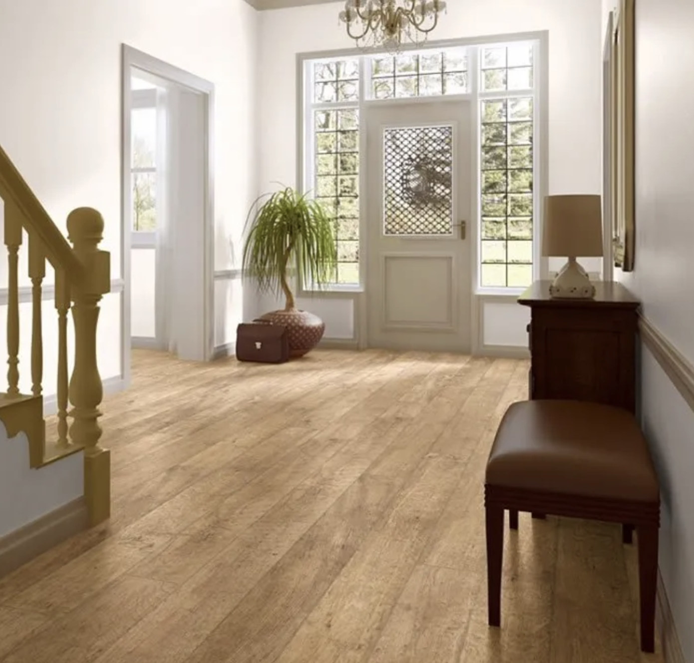 A bright foyer with hardwood floors, a large front door with glass panels, and a small table with a lamp. There is a potted plant near the door and a chandelier hanging from the ceiling.