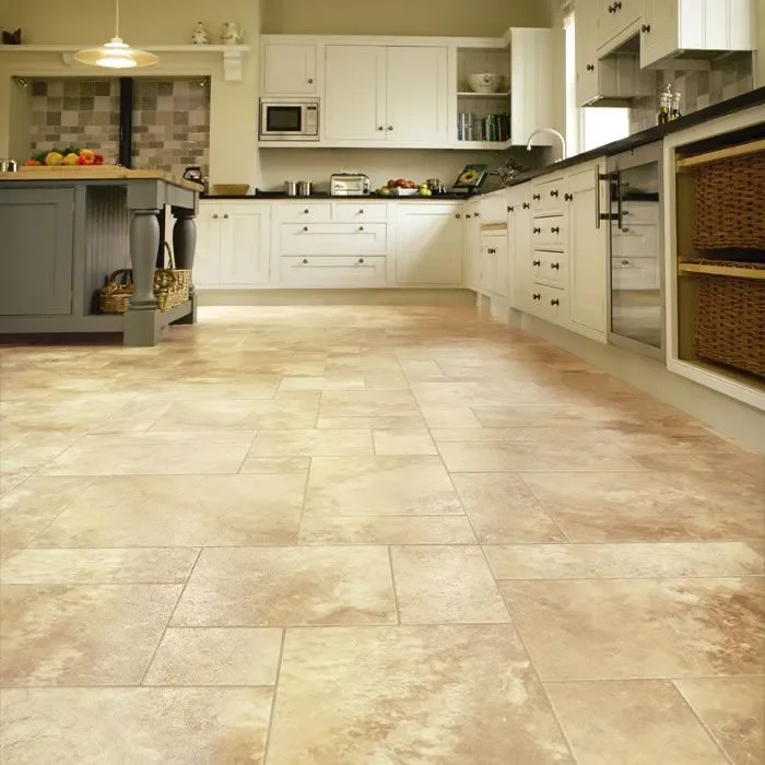 Kitchen with light-colored cabinets, a gray island, tiled backsplash, and tiled floor.
