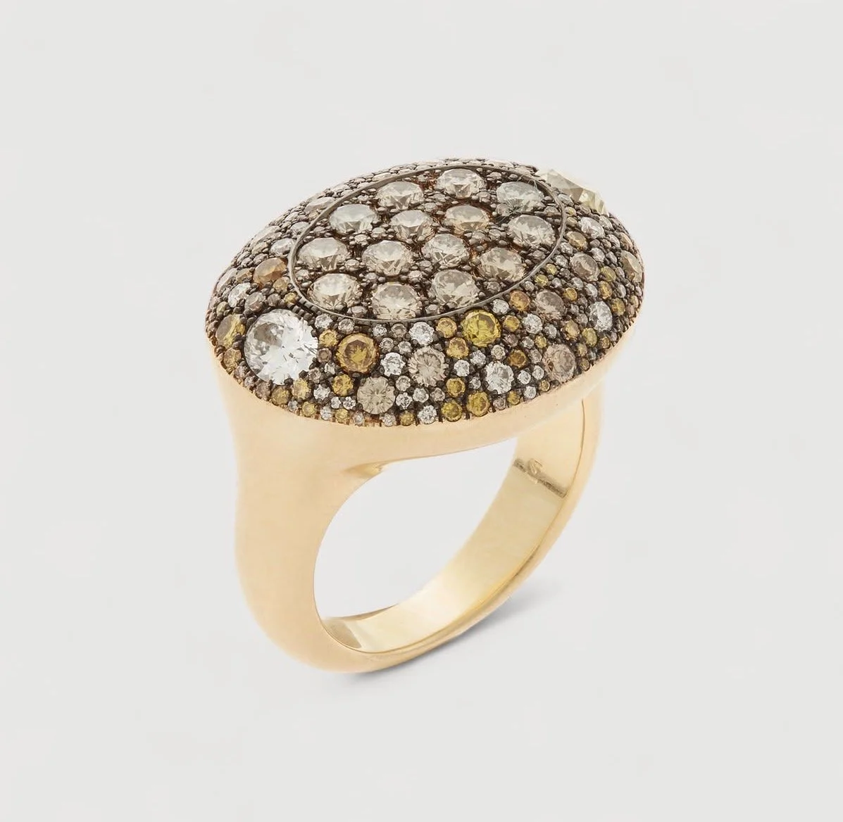 Gold ring with an oval top encrusted with numerous small, round gemstones, including clear, yellow, and brown stones.