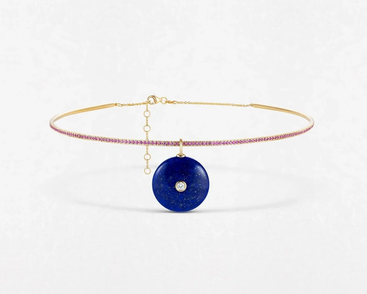 Gold necklace with pink gemstones and a large blue circular pendant with a small diamond at the center.