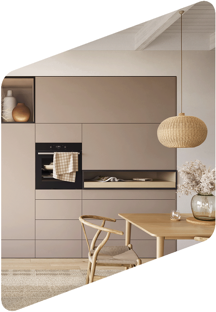 Cuisine moderne avec armoires rose poudré, un four intégré, une table en bois avec une chaise et une table en bois naturel, une lampe en rotin suspendue, une vase avec des fleurs blanches.