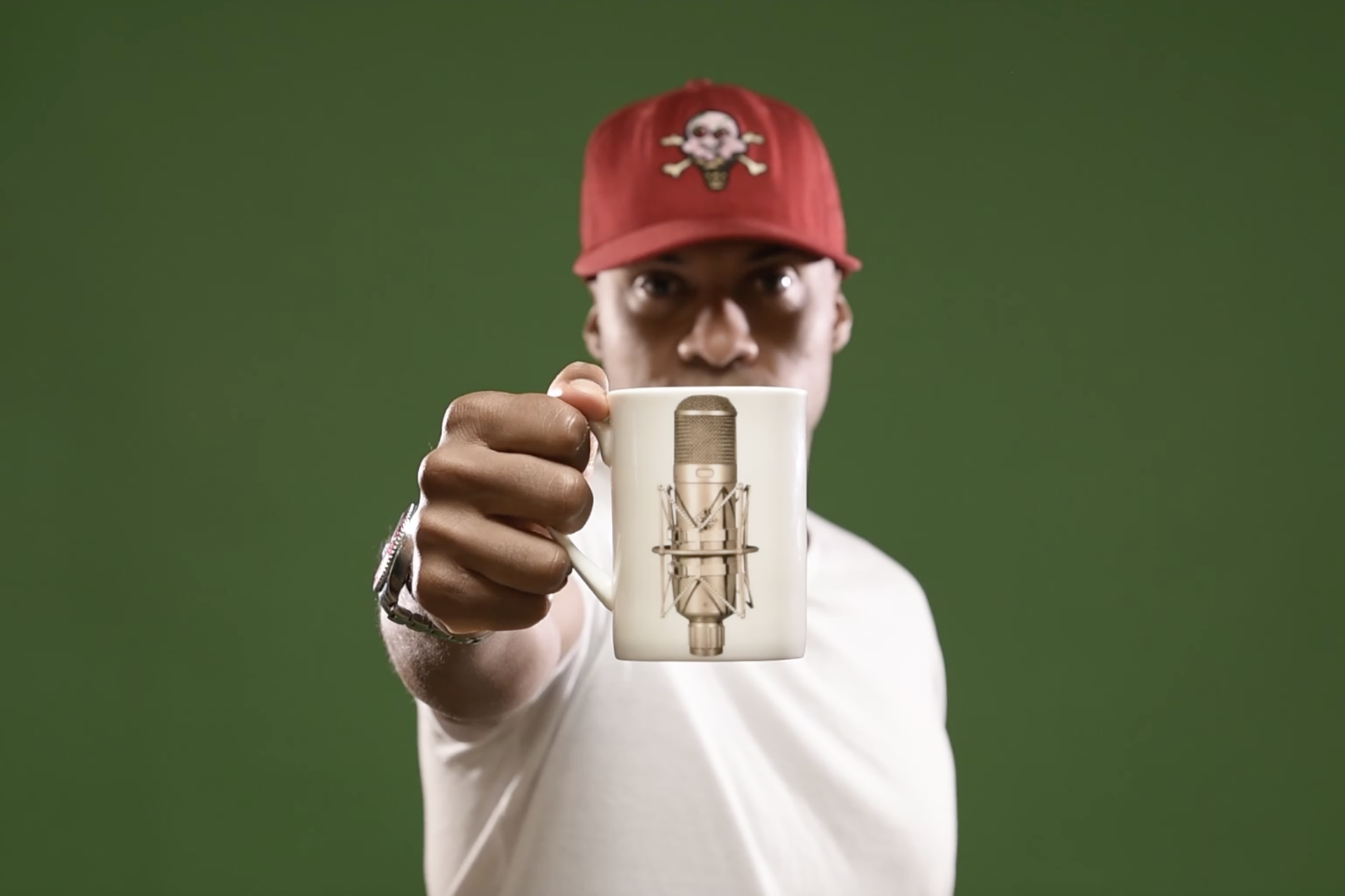 dynamite mc holding a cup with a classic studio microphone on it
