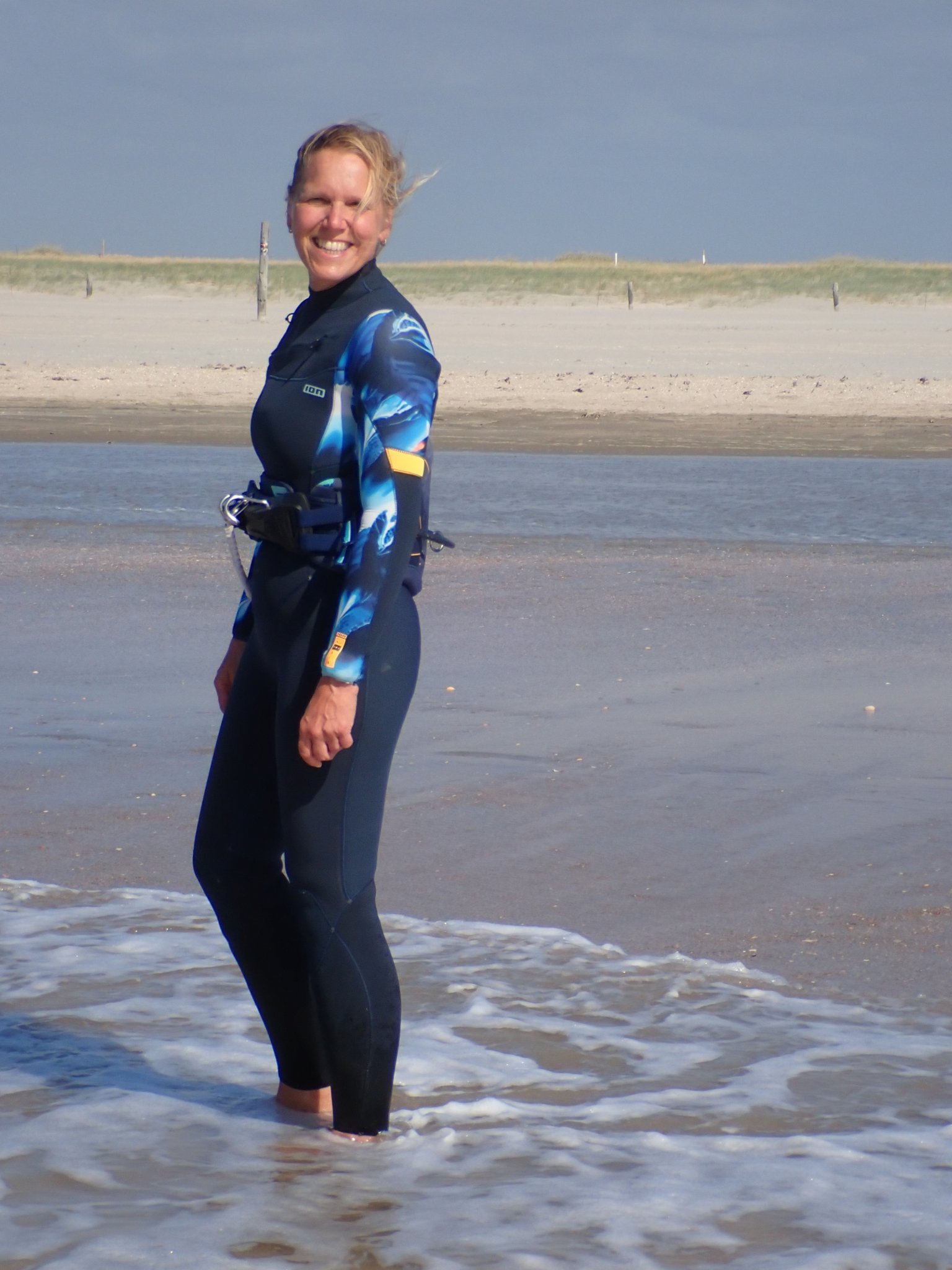 Daniela, Inhaberin von Assistella, am Strand, die ihre Leidenschaft für Norddeutschland und die Natur zeigt.