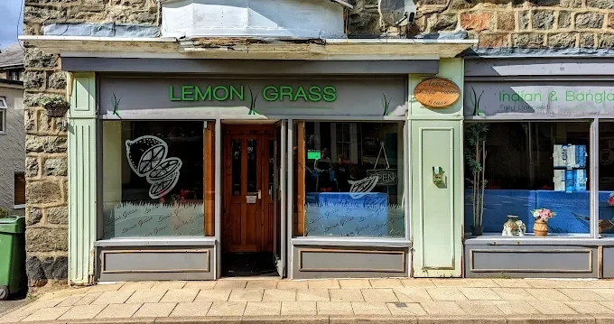 Small restaurant with green trim named Lemon Grass, offering Indian and Bangladeshi cuisine in Dolgellau. Large windows display the interior, with a door in the center.