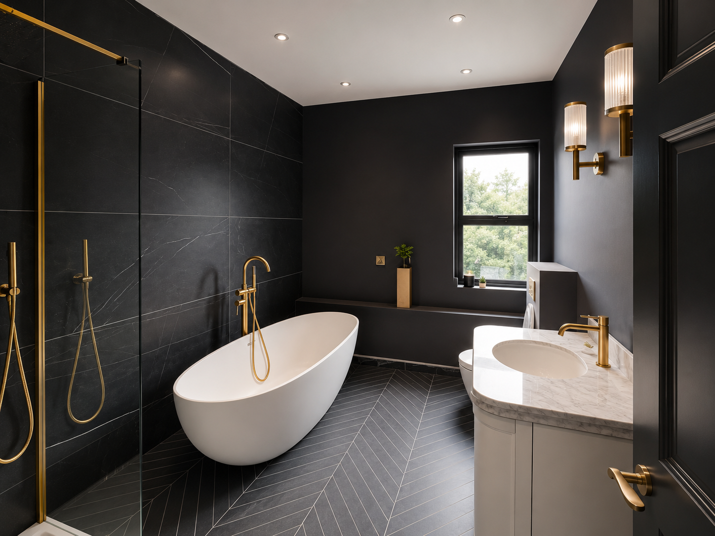 Modern bathroom with black walls, black tiled floor with white lines, white freestanding bathtub with gold fixtures, marble sink with gold faucet, window with green trees outside, and wall-mounted gold light fixtures.