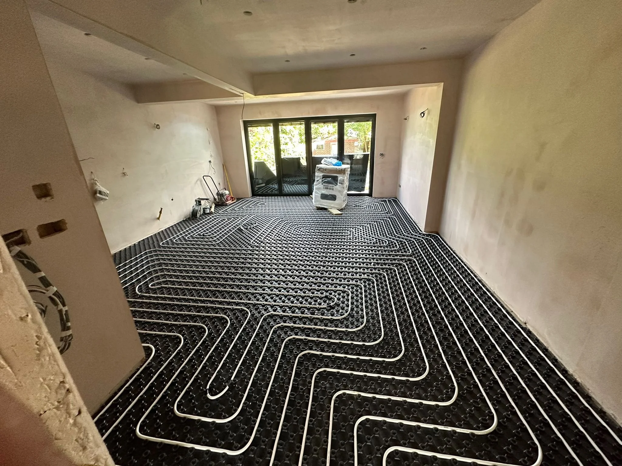 Interior of a room under construction with radiant heating flooring system installed.