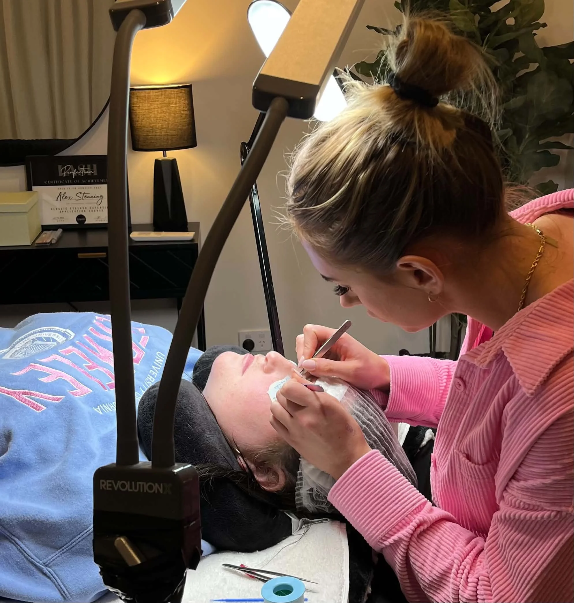 Lash student practising eyelash extension application on a live model during professional training