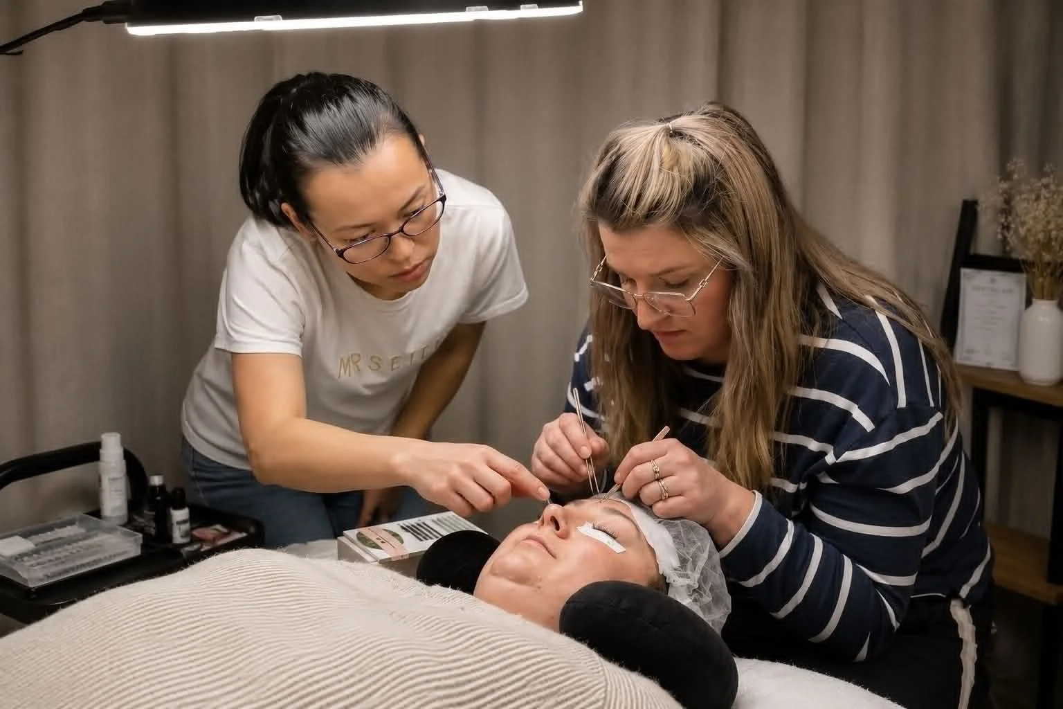 Lash student practising eyelash extension techniques on a live model during beginner lash training