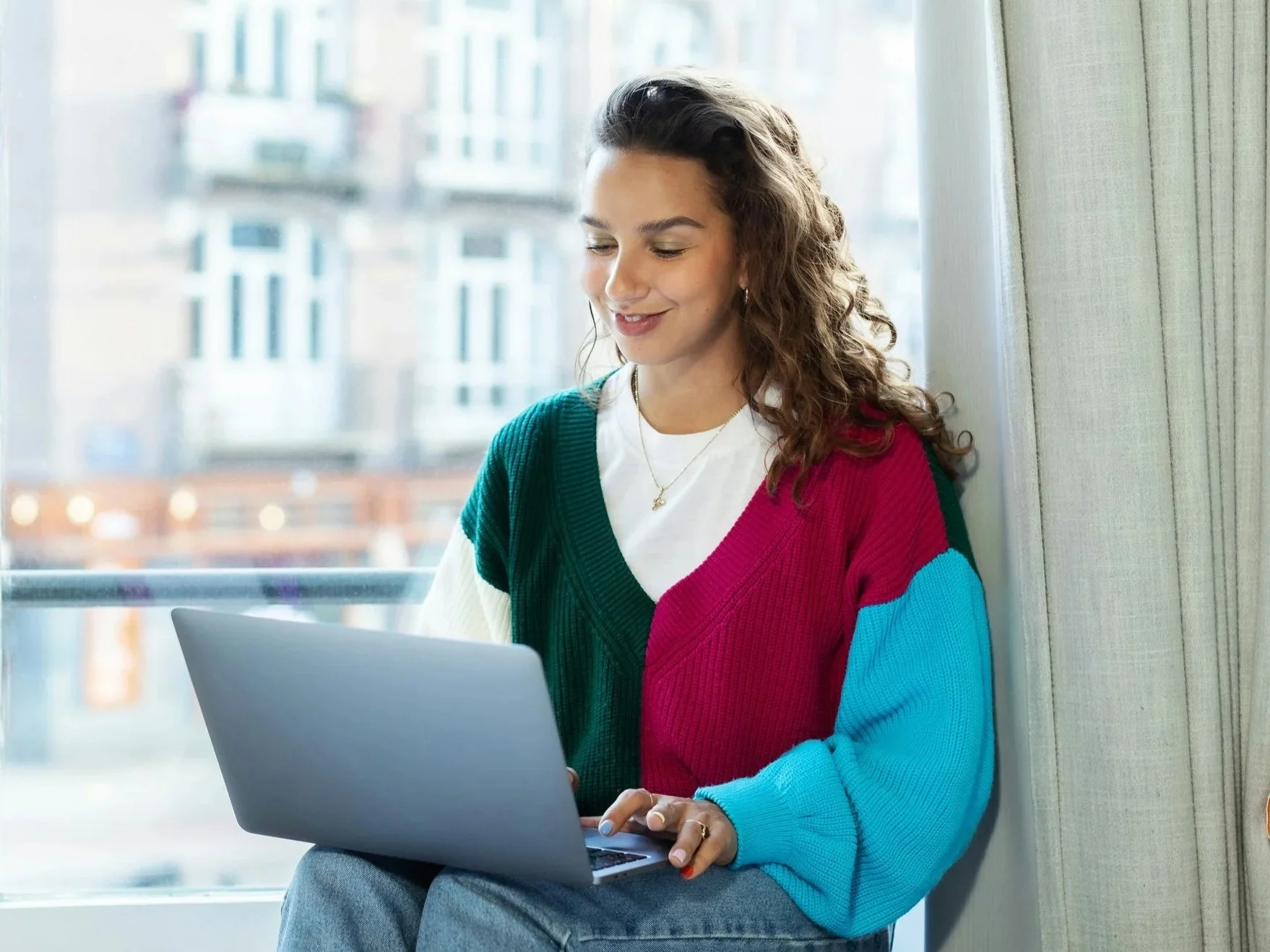 Young happy woman working from home on laptop