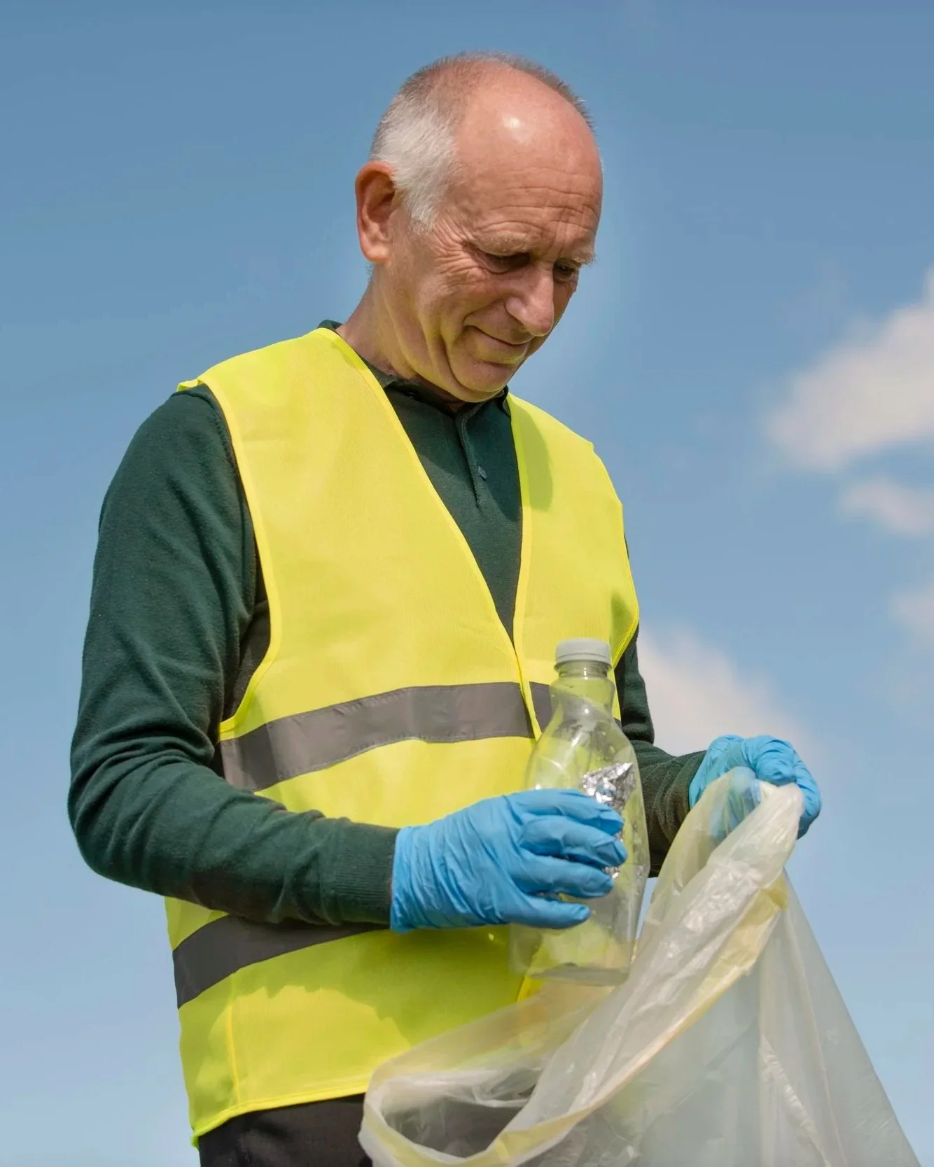 Older man wearing high vis and collecting rubbish