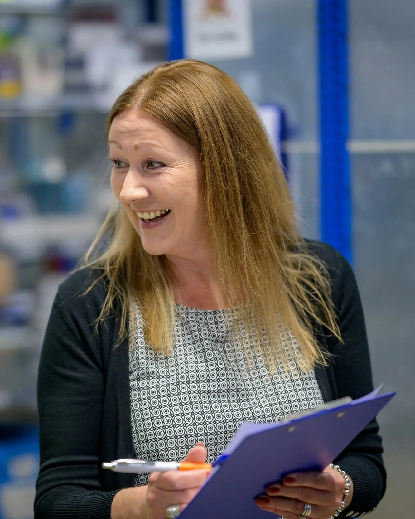 A happy woman writing on a clipboard