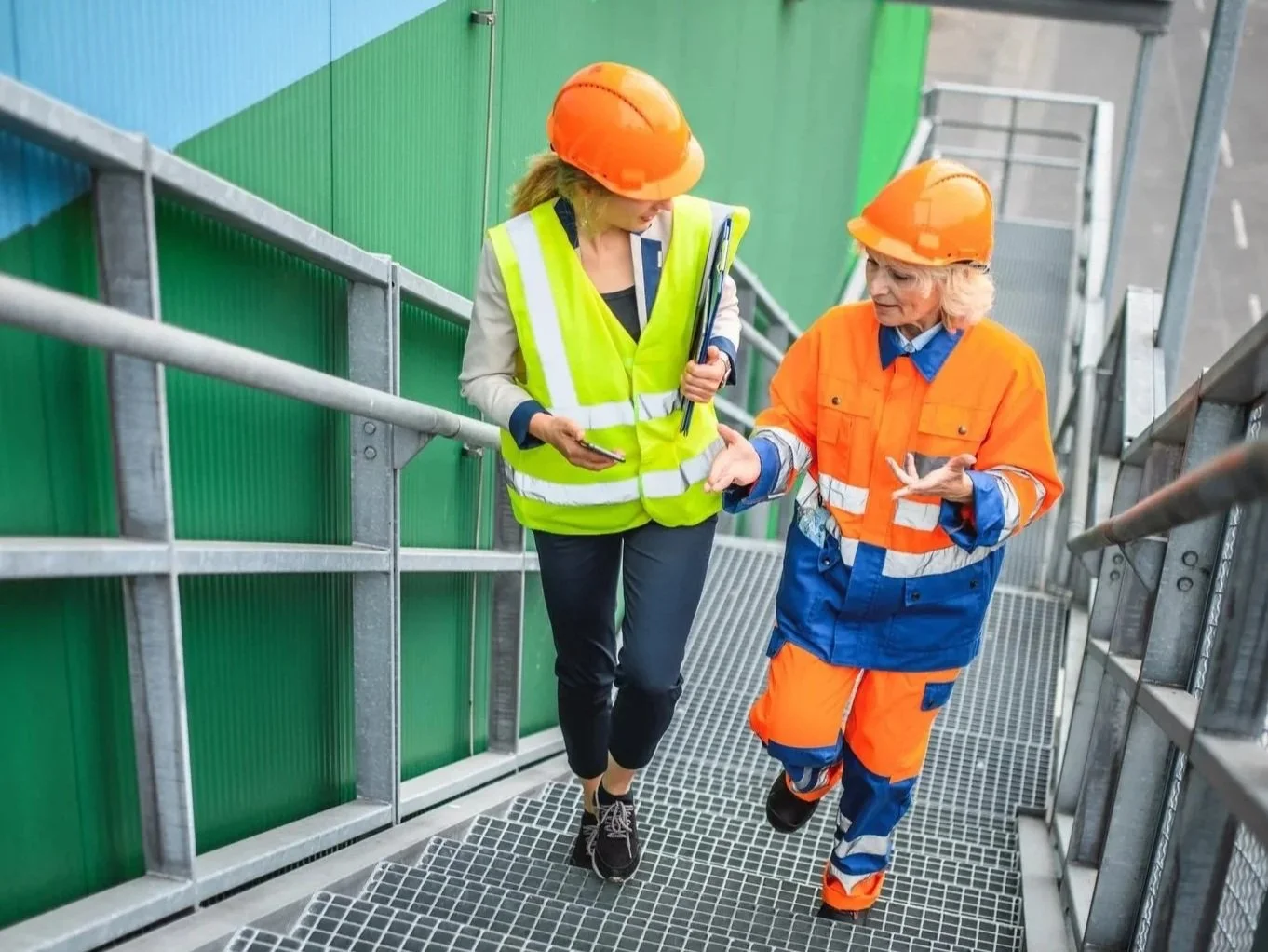 Two female recycling workers walking up the steps