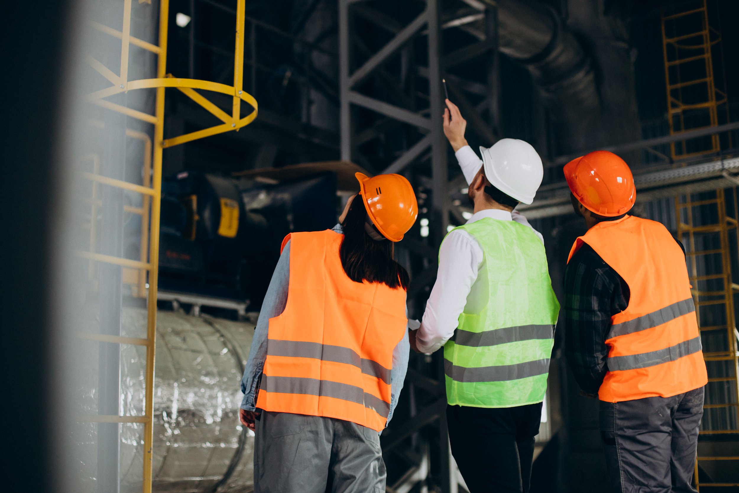 Team leader showing two young employees around a site