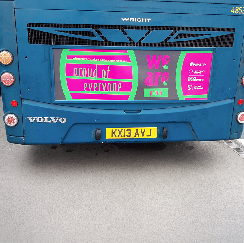 Image of the back of an Arriva bus showing grey, pink and green DNA saying proud of everyone