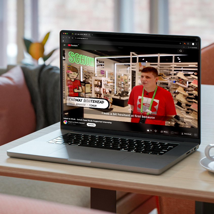 An image of a laptop on a table showing on the screen one of the videos of an intern who had completed the programme and found full time work