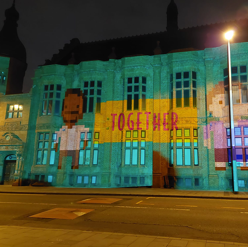 An image of the Florrie in Dingle, Liverpool with two game characters projected on to the side and togethers written between them