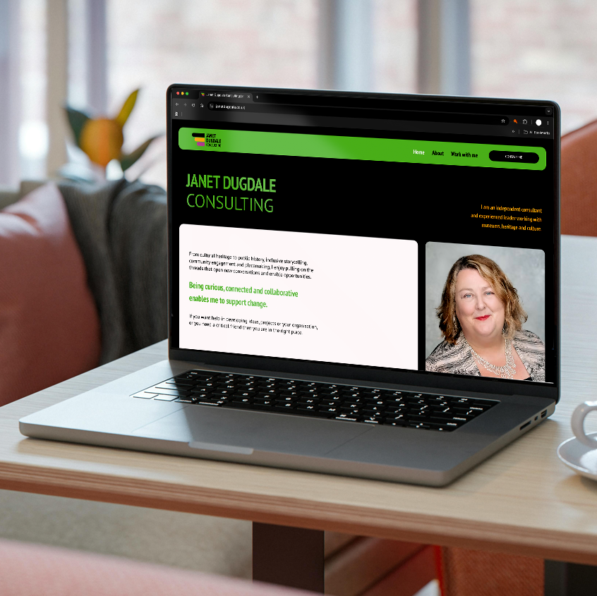 An image of a laptop on a table open with www,janetdugdale.co.uk on the screen