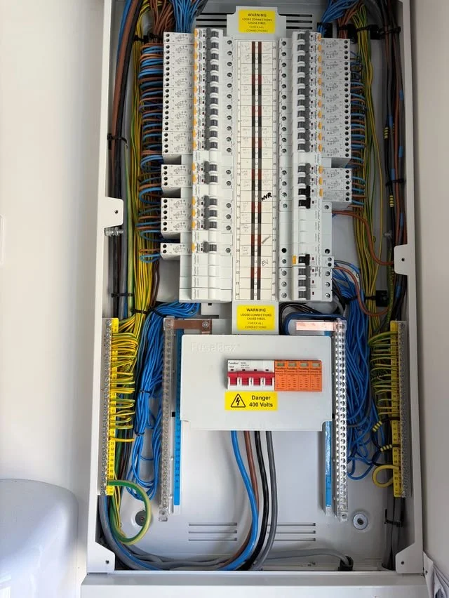 An electrical panel with multiple circuit breakers and wiring.