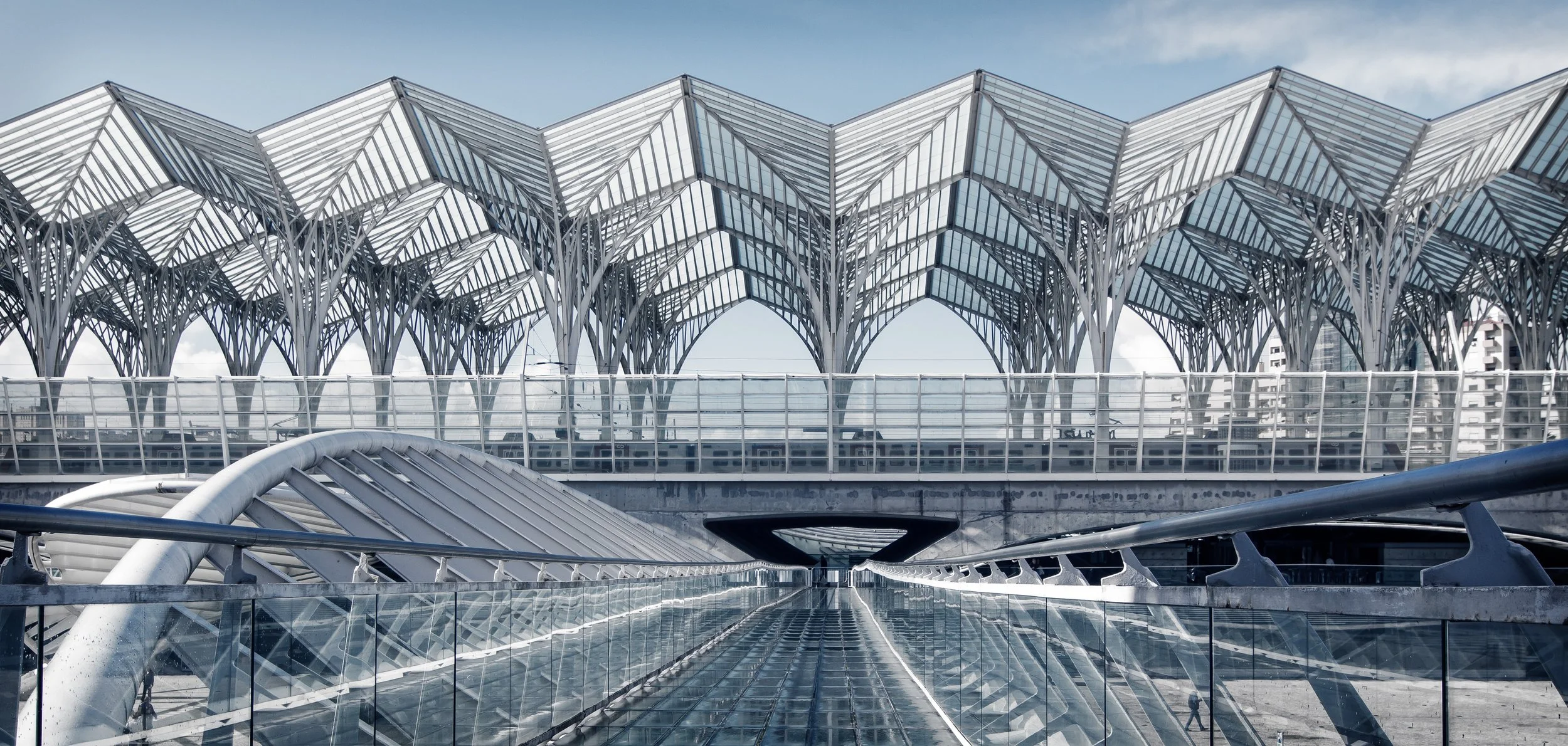 A film and photo location in Portugal from walnut films, Architectural structure with a glass and metal roof featuring pointed arch designs, part of a modern building or transportation hub.