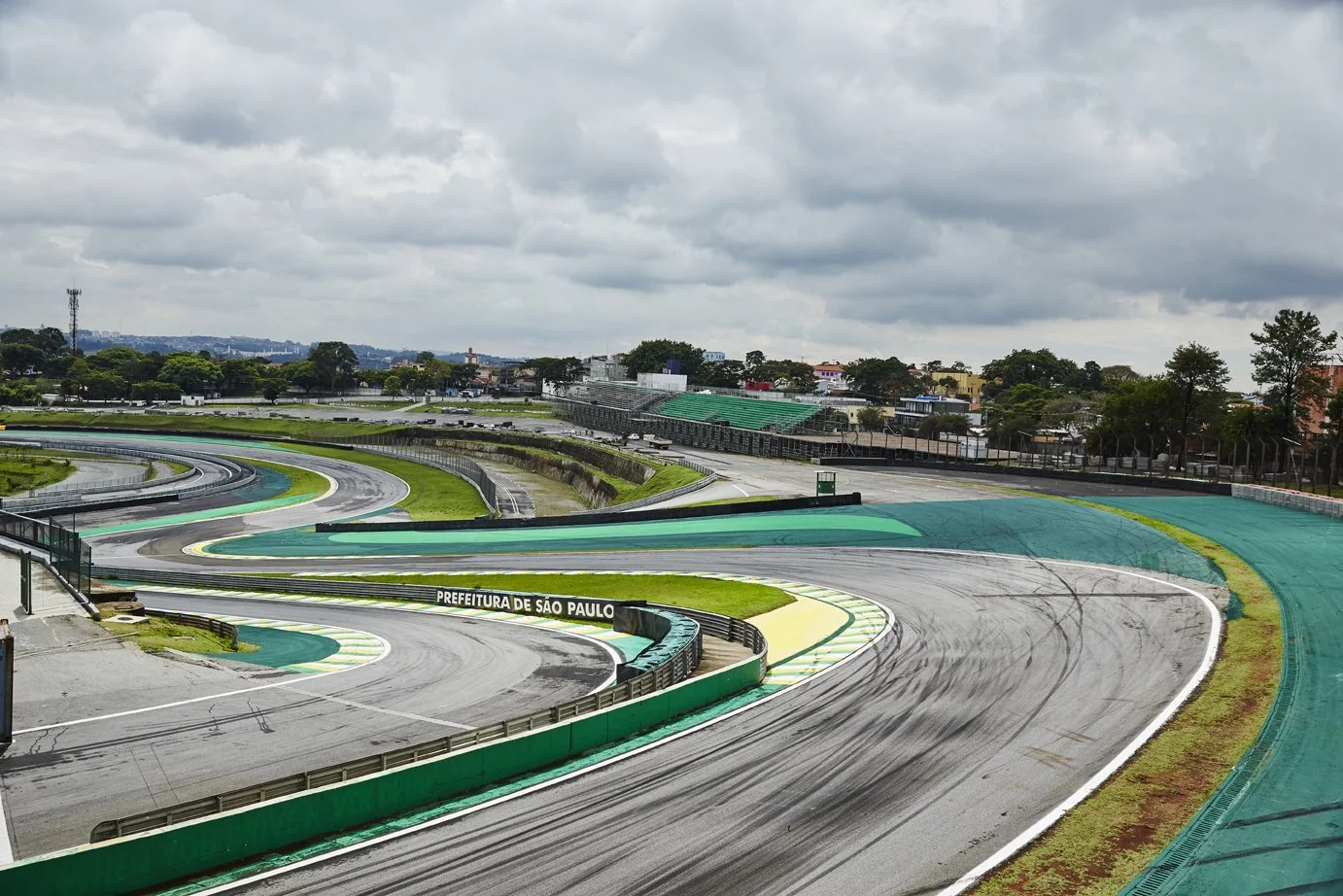 Empty race track at Autodromo Nazionale Monza, with tire skid marks, overcast sky, and trees in the background.