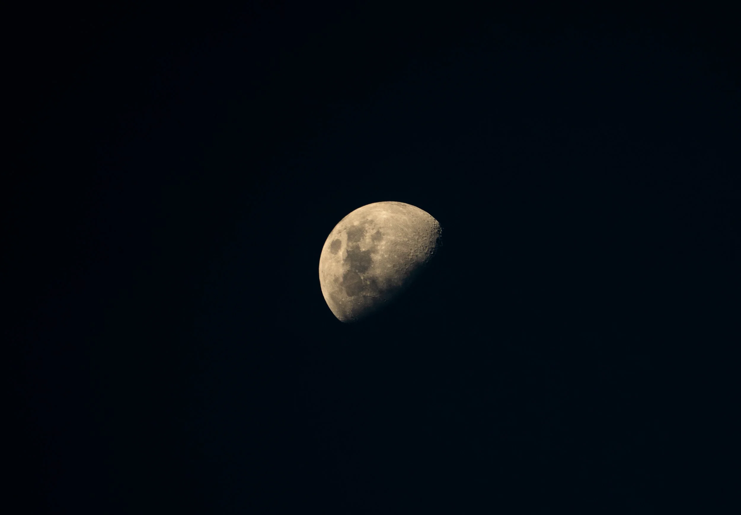 A photograph of the moon in its waxing gibbous phase against a dark night sky.