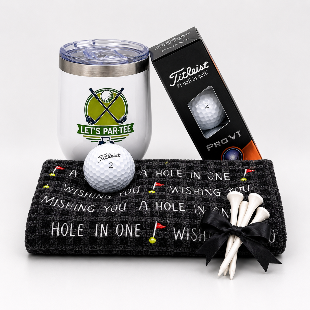 The Petite 19th Hole golf gift box with a golf-themed tumbler, three Titleist Pro V1 golf balls, a Par Bleu golf towel, and bamboo golf tees