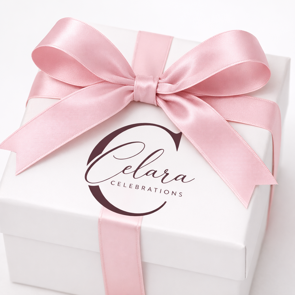 White gift box with a pink satin ribbon tied in a bow, label reads 'Celara Celebrations'.