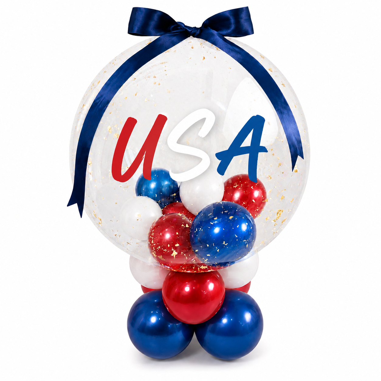 Balloon centerpiece with red, white, and blue balloons, a large clear balloon with "USA" written on it, decorated with gold confetti and tied with a blue ribbon, symbolizing American patriotism.