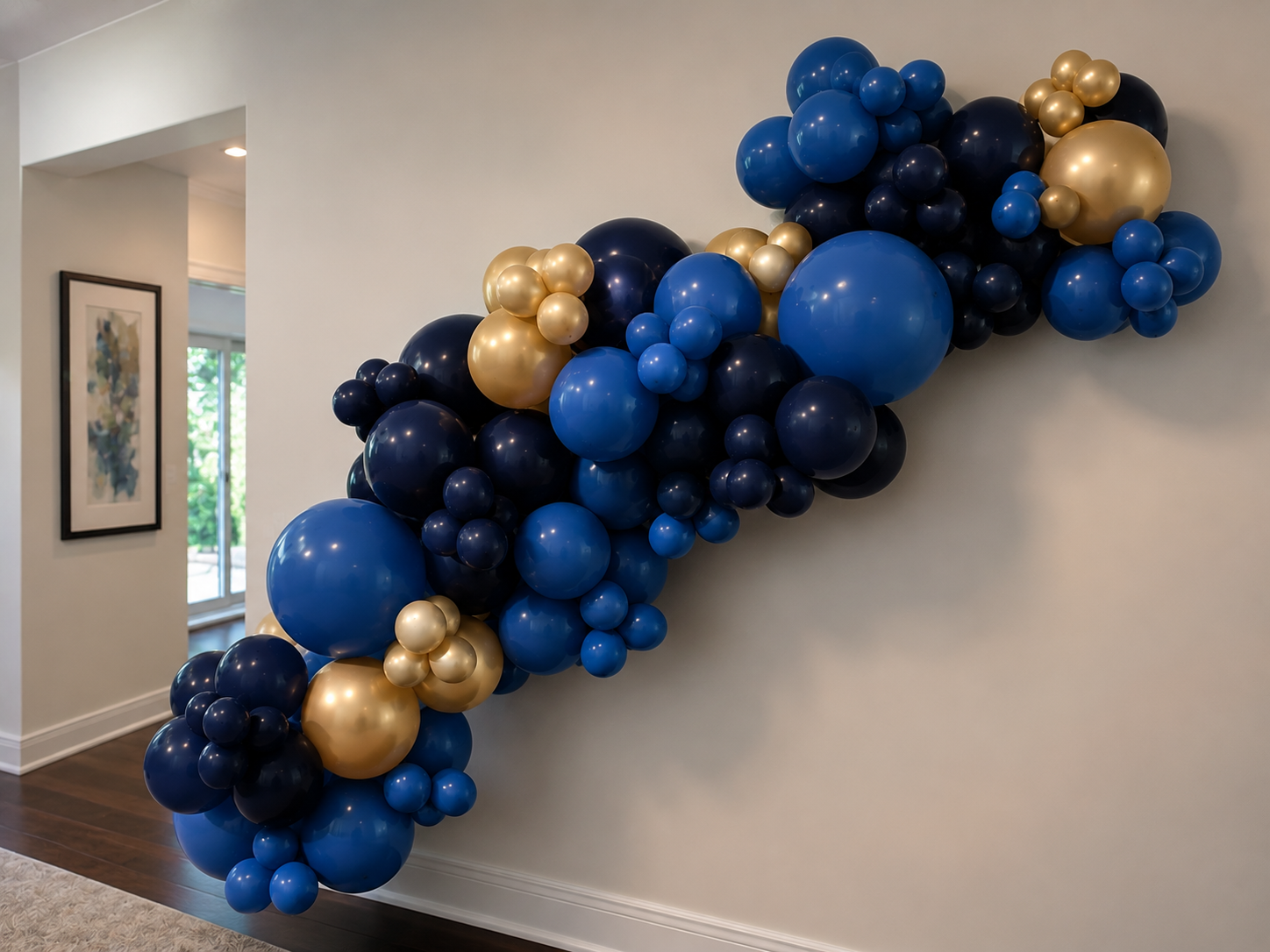 Balloon decoration with blue, gold, and black balloons arranged on a wall