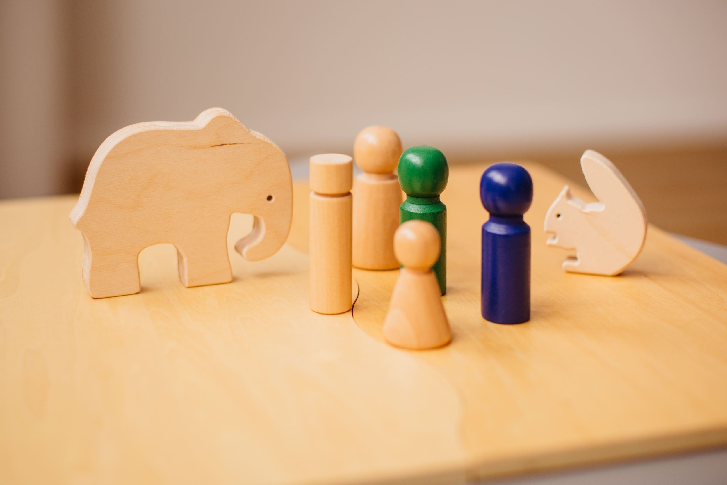 Holzspielzeug mit Tierformen und bunten Figuren auf einem Holztablett